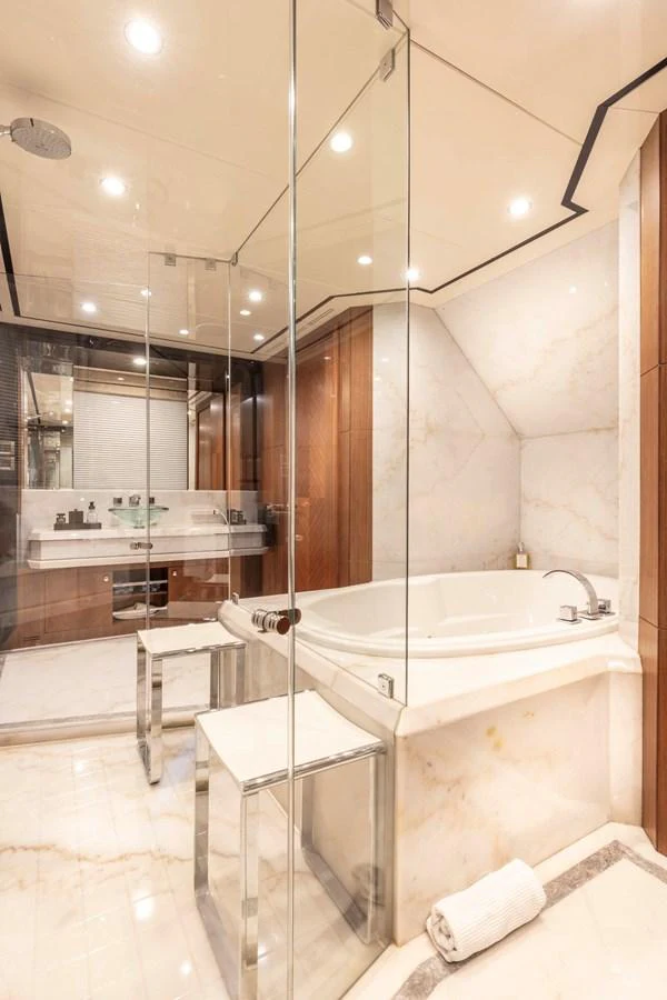 The luxurious bathroom features a spacious bathtub and elegant marble finishes. aboard WRECKLESS Yacht for Sale