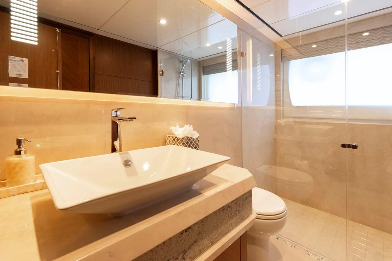 The yacht's bathroom features a modern design with a sleek sink and spacious shower area. aboard WRECKLESS Yacht for Sale