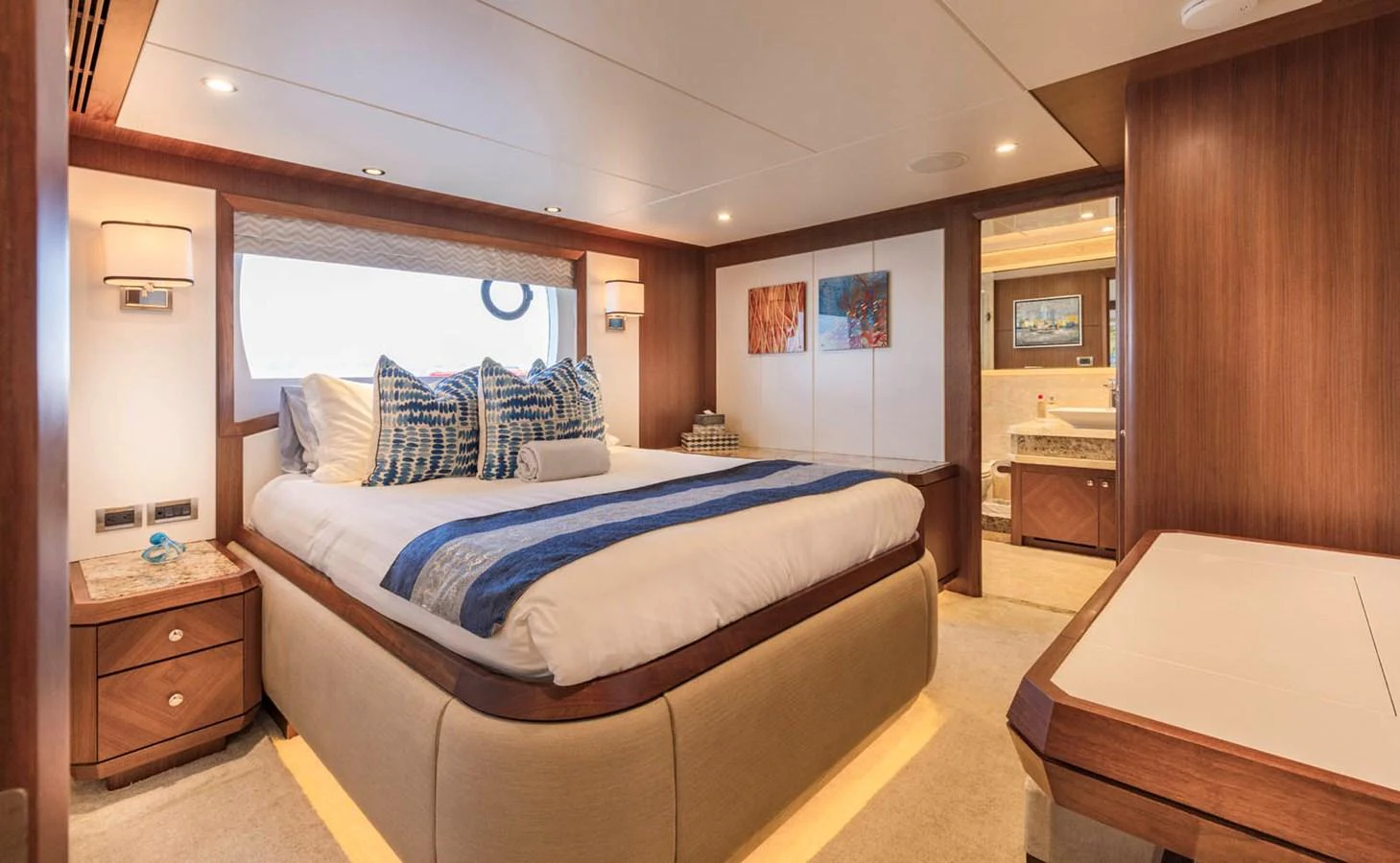 The master stateroom features a spacious bed, elegant wood finishes, and ample natural light. aboard WRECKLESS Yacht for Sale