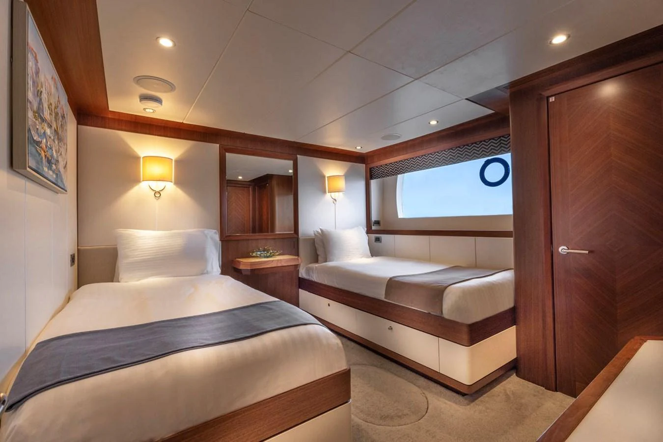The guest stateroom features twin beds with elegant wood finishes and soft lighting. aboard WRECKLESS Yacht for Sale