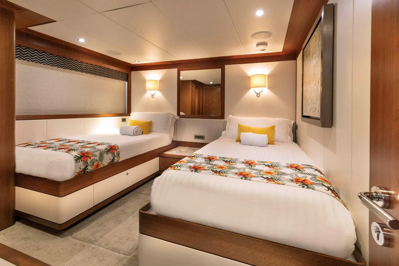 The guest stateroom features twin beds with vibrant bedding and warm wood accents. aboard WRECKLESS Yacht for Sale