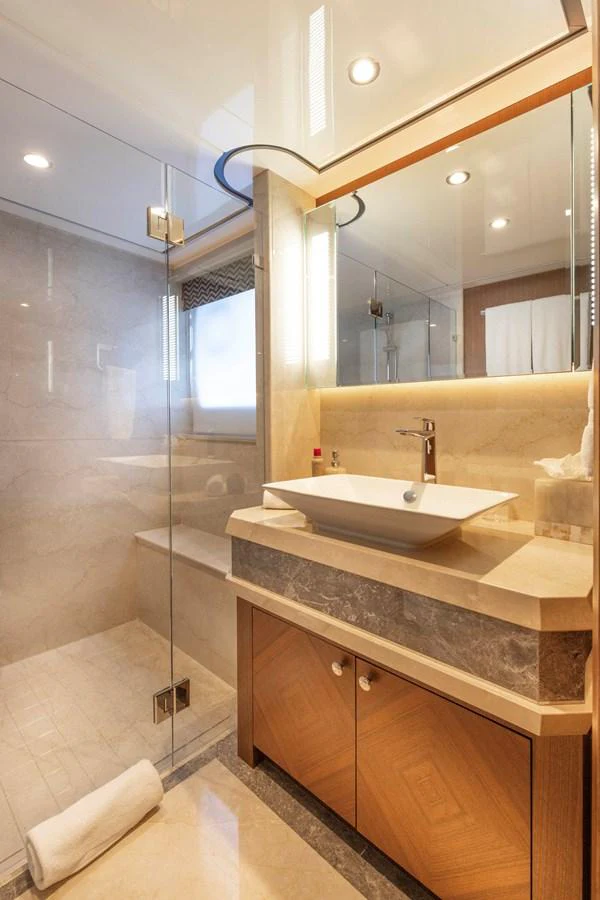 A luxurious yacht bathroom featuring a modern sink and a spacious glass-enclosed shower. aboard WRECKLESS Yacht for Sale