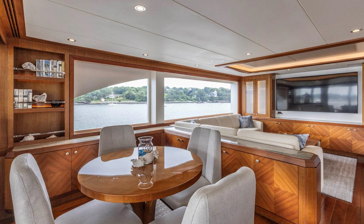 The salon features elegant wood finishes, comfortable seating, and large windows offering scenic views. aboard WRECKLESS Yacht for Sale