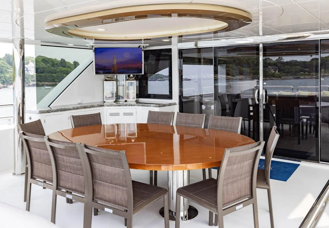 The yacht features a spacious and elegant dining area with a large round table and comfortable seating. aboard WRECKLESS Yacht for Sale