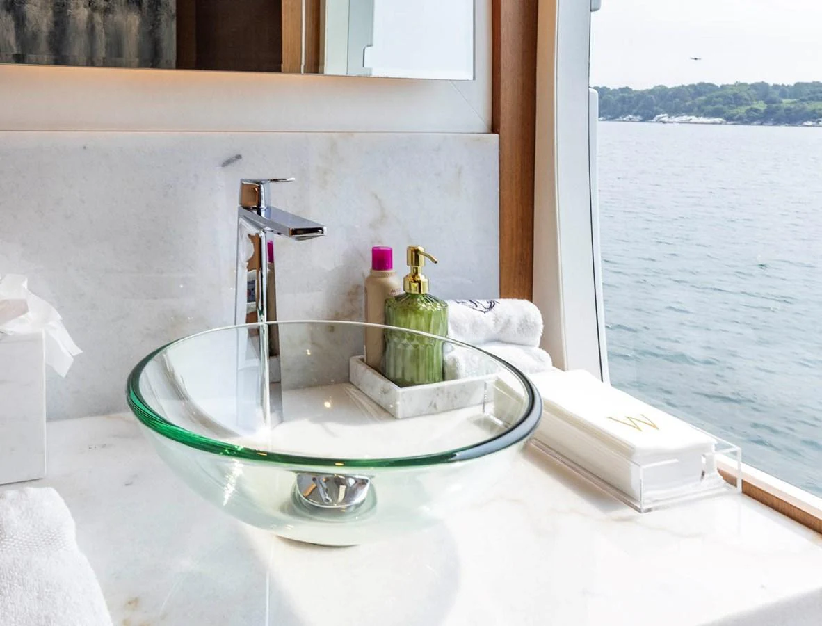 A stylish bathroom with a glass sink and a view of the sea. aboard WRECKLESS Yacht for Sale