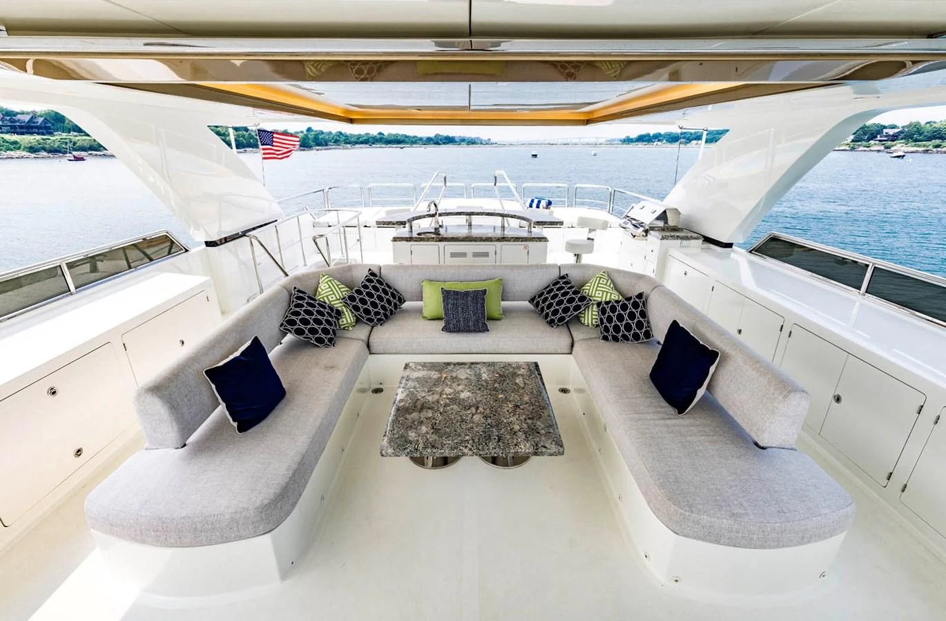 The aft deck features a spacious seating area with plush cushions and a stylish table, offering a perfect spot for relaxation and socializing while enjoying the view. aboard WRECKLESS Yacht for Sale