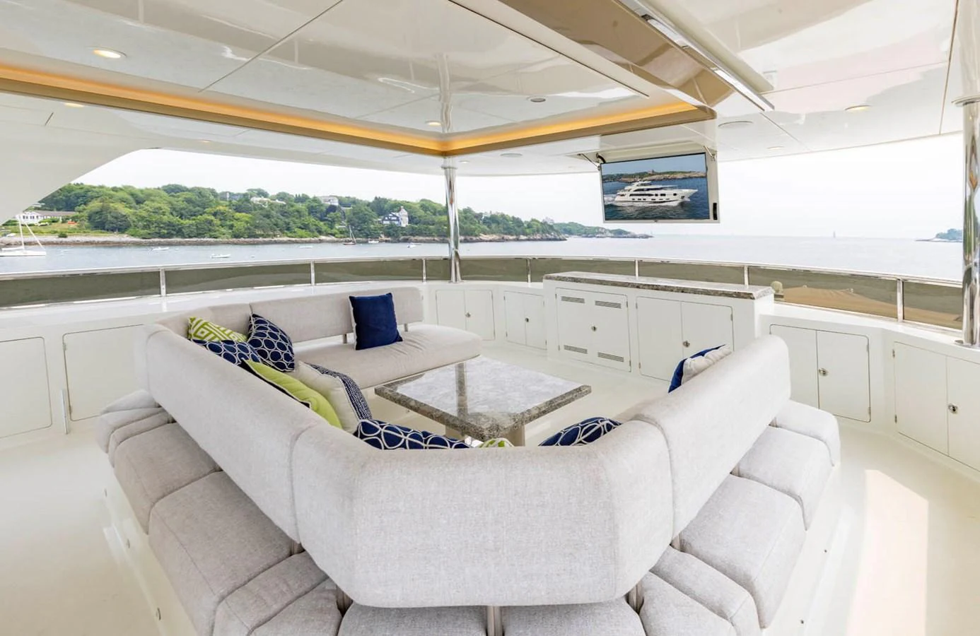 The flybridge features a spacious seating area with plush cushions and a large table, offering stunning views of the surrounding waters. aboard WRECKLESS Yacht for Sale