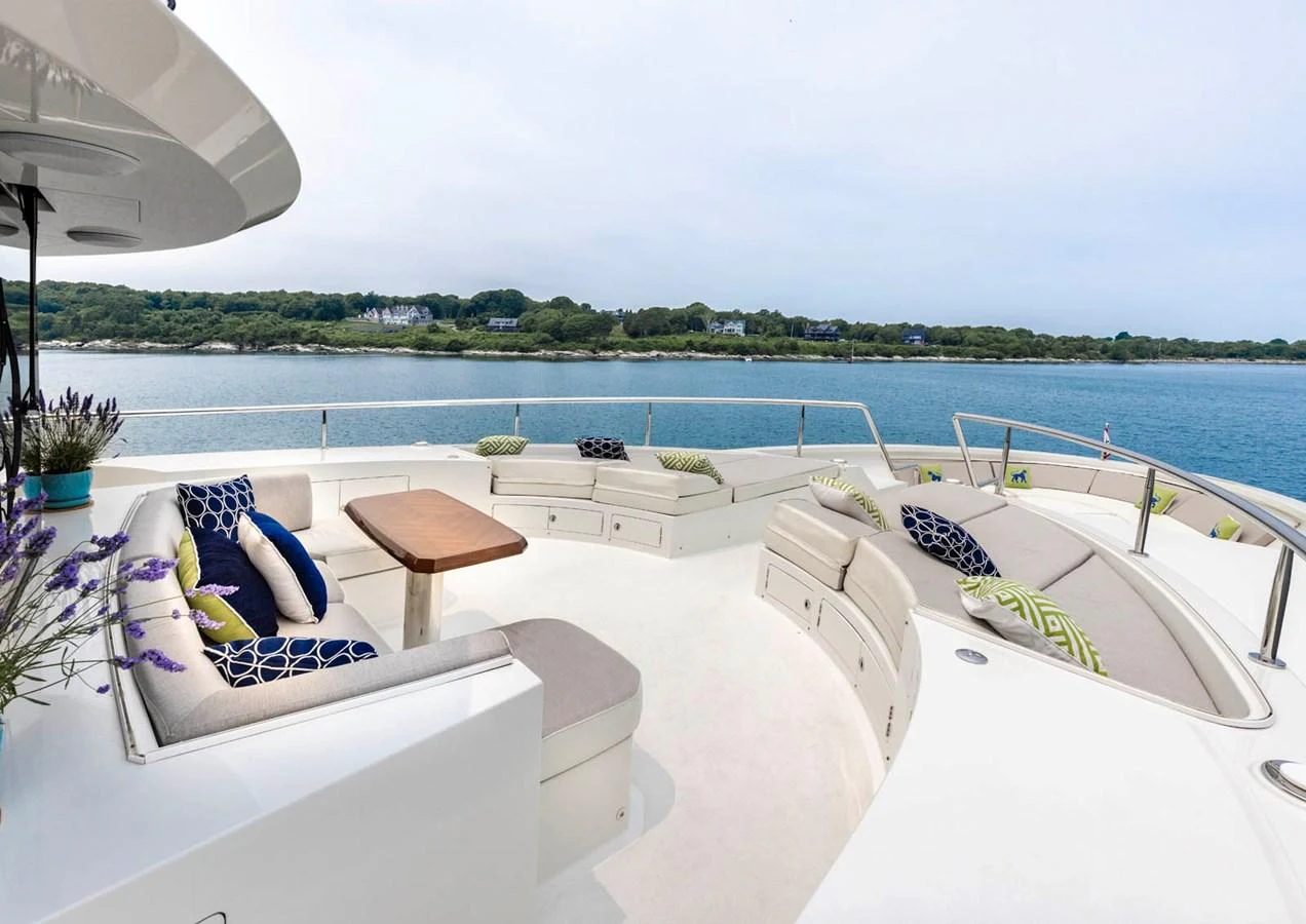 The yacht features a spacious and inviting bow seating area with plush cushions and a wooden table, perfect for relaxation and socializing while enjoying scenic views. aboard WRECKLESS Yacht for Sale