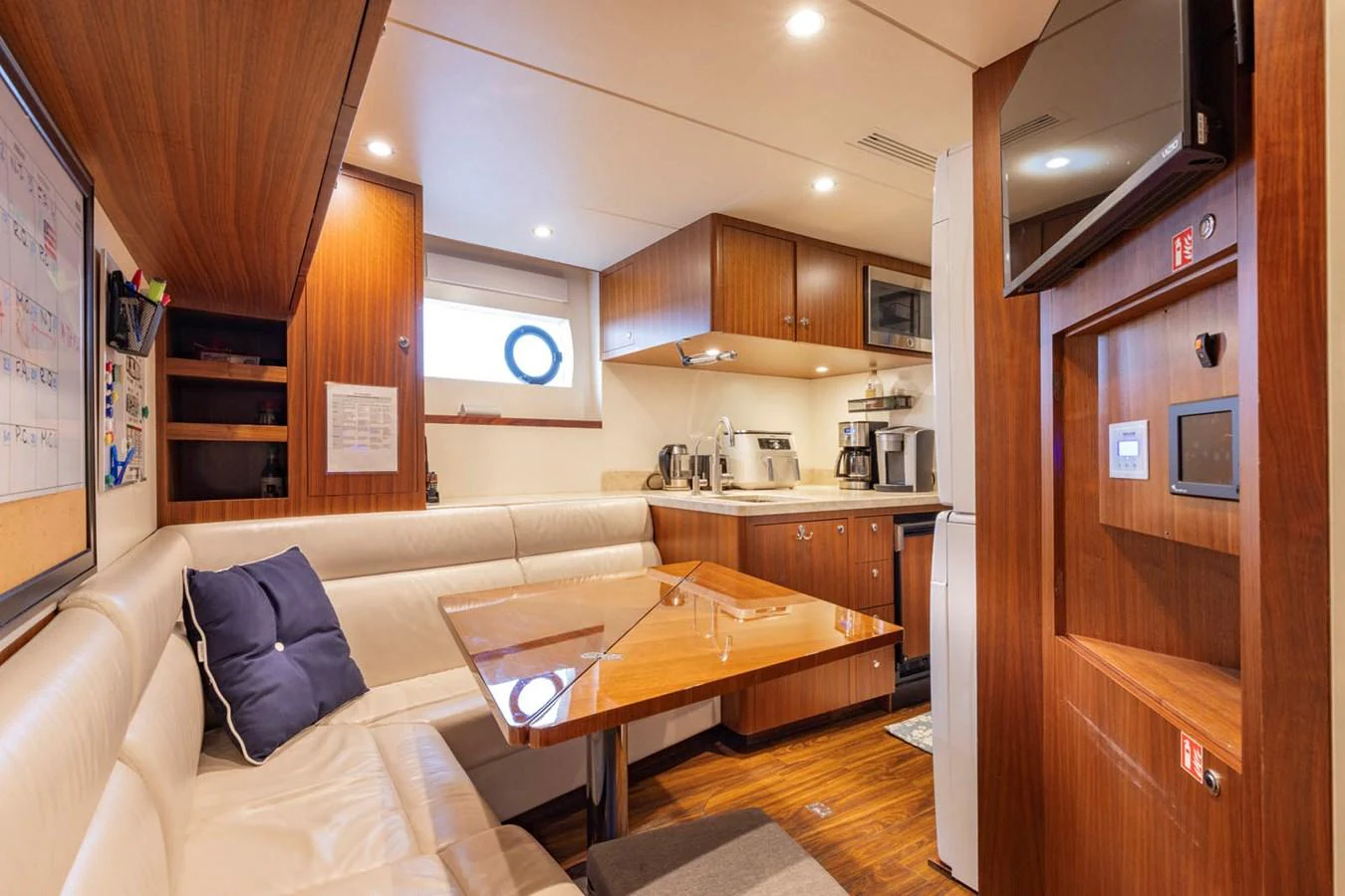 The galley features a cozy dining area with a wooden table and built-in seating, complemented by modern kitchen appliances. aboard WRECKLESS Yacht for Sale
