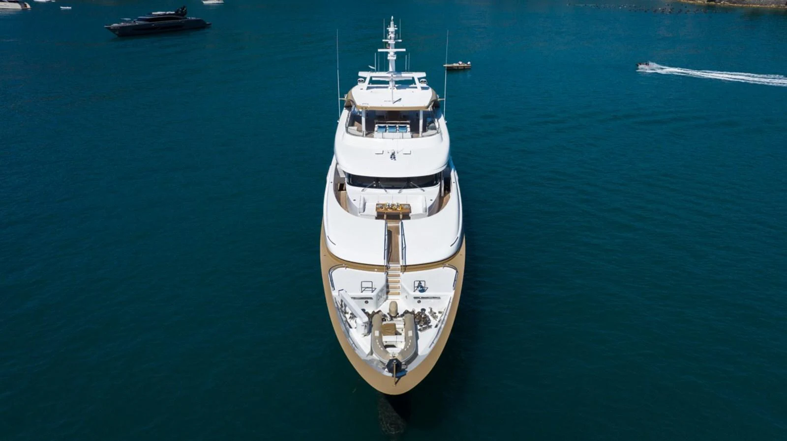 A luxurious yacht is anchored in serene blue waters, showcasing its elegant design from a head-on perspective. aboard PICK UP Yacht for Sale