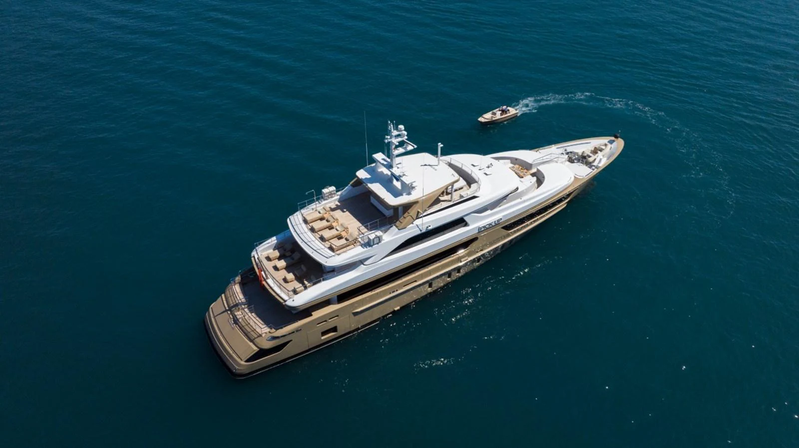A luxurious yacht glides through the deep blue sea, accompanied by a tender. aboard PICK UP Yacht for Sale