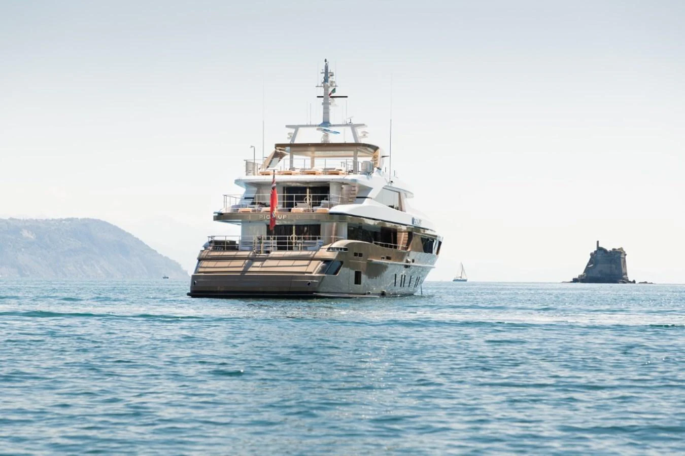 A luxurious yacht is anchored in serene waters with a scenic backdrop. aboard PICK UP Yacht for Sale