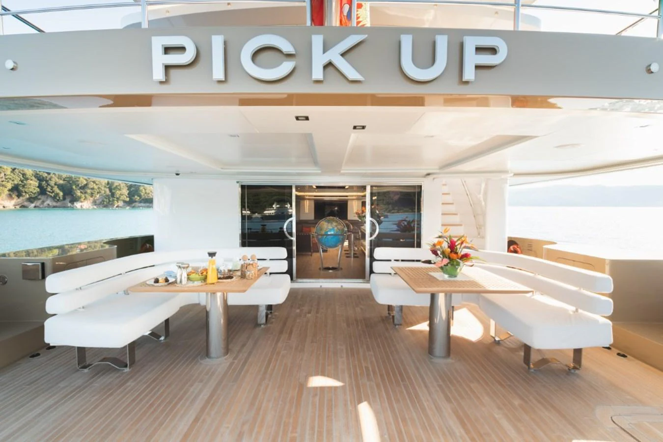 The aft deck features elegant seating and dining areas with a beautiful view of the surroundings. aboard PICK UP Yacht for Sale