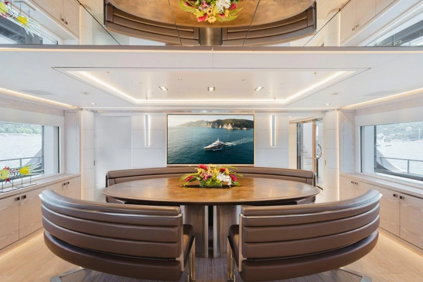 The yacht's dining area features a sleek, modern design with a large oval table and comfortable seating, complemented by a scenic view through the windows. aboard PICK UP Yacht for Sale