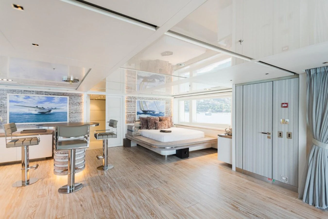 A spacious and modern stateroom with a large bed and seating area, featuring elegant decor and ample natural light. aboard PICK UP Yacht for Sale