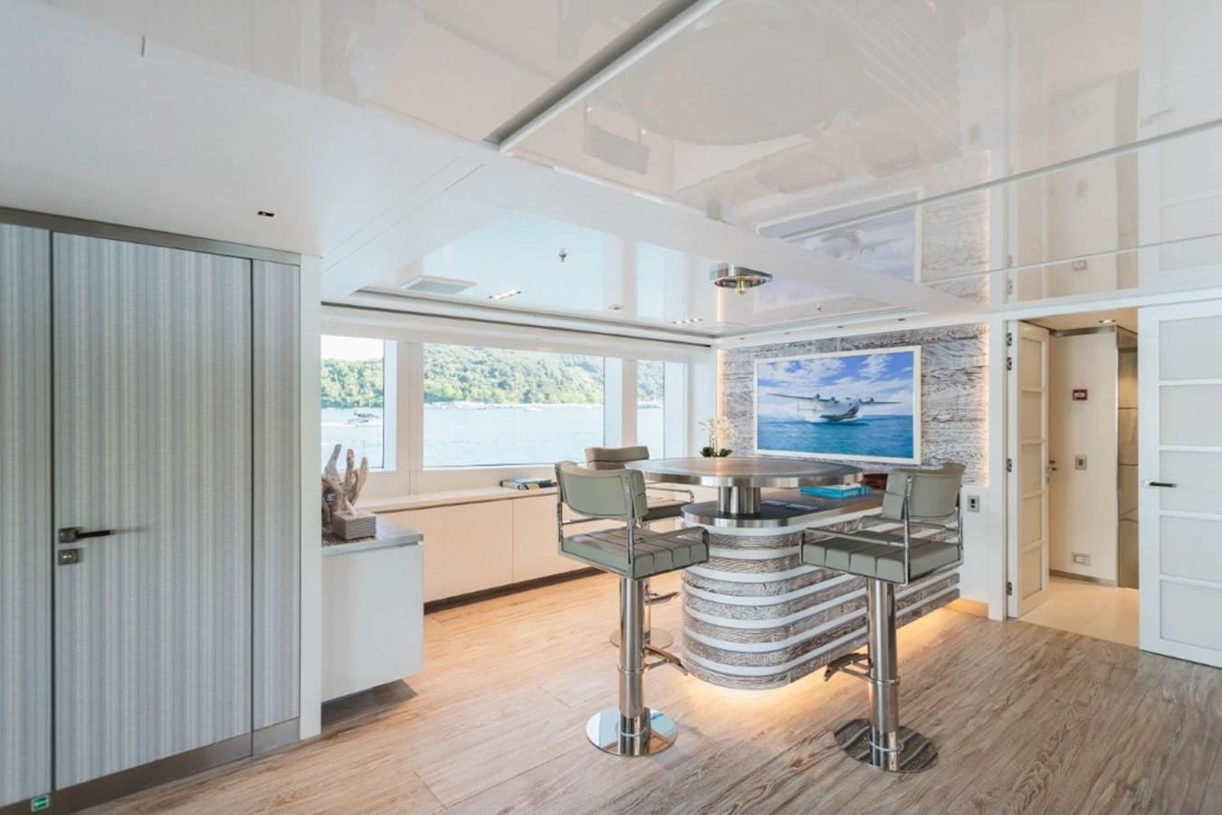 The yacht's salon features a modern design with a bar area and a large window offering scenic views. aboard PICK UP Yacht for Sale