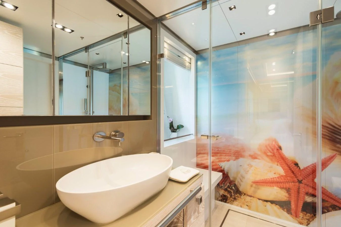 The yacht's bathroom features a modern design with a large sink and a vibrant, beach-themed shower area. aboard PICK UP Yacht for Sale