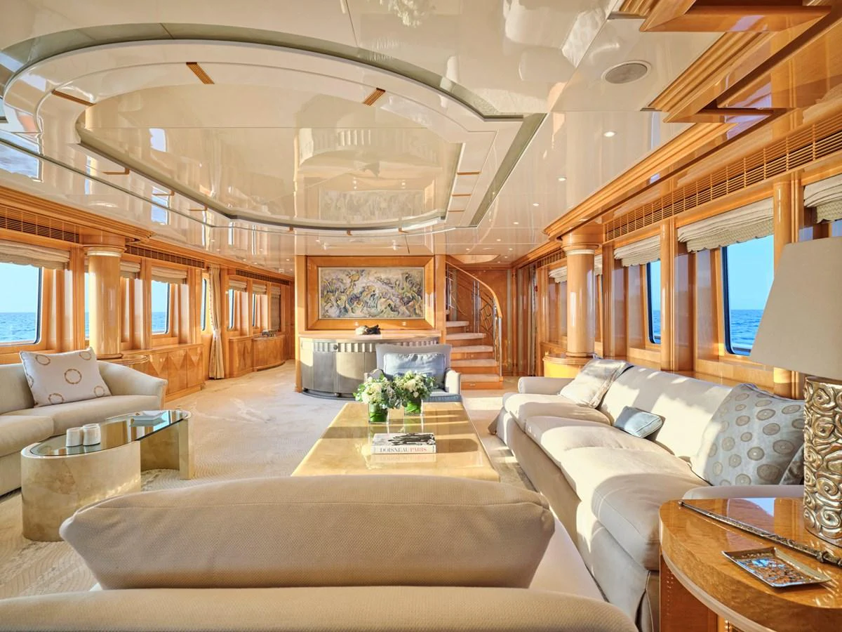 The salon features luxurious seating, elegant woodwork, and expansive windows offering stunning sea views. aboard BILMAR Yacht for Sale
