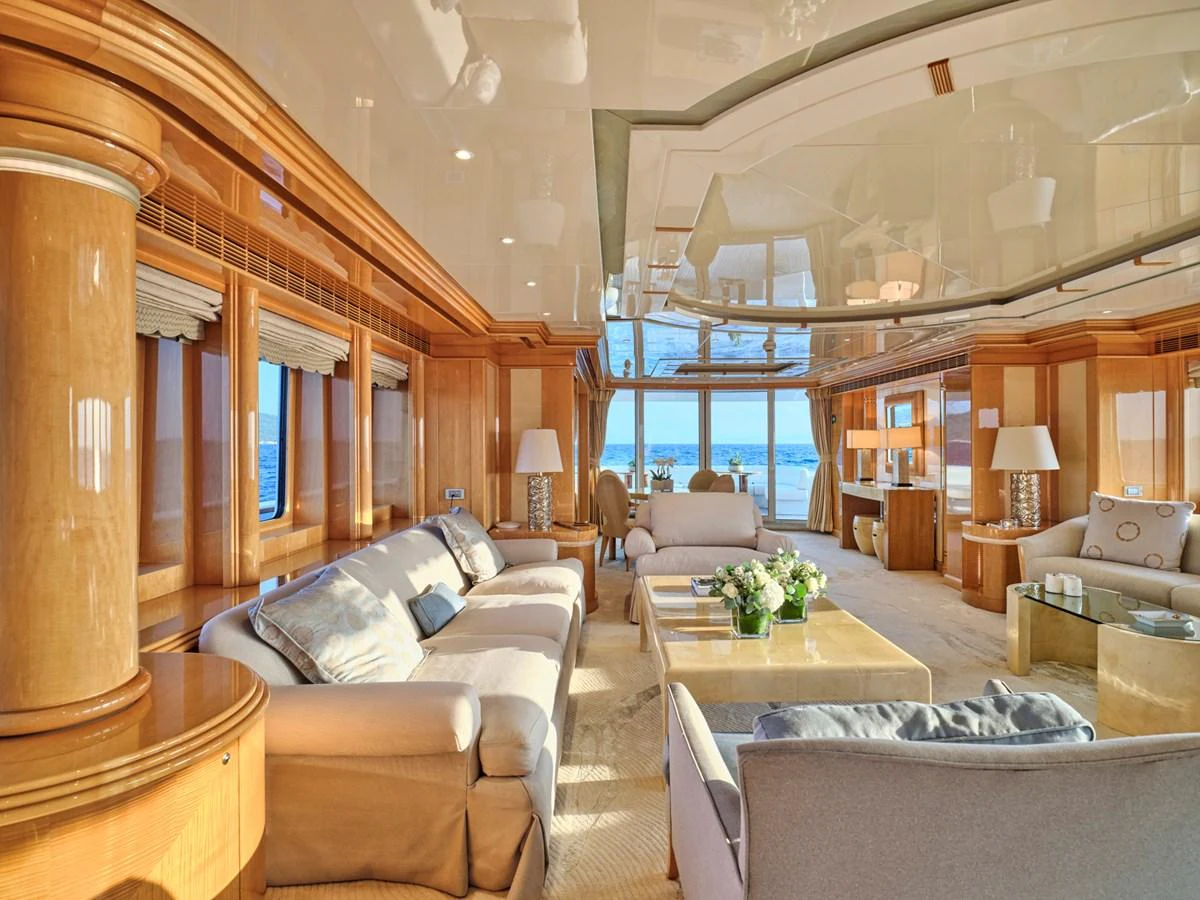 The salon features luxurious seating with panoramic ocean views and elegant wooden accents. aboard BILMAR Yacht for Sale