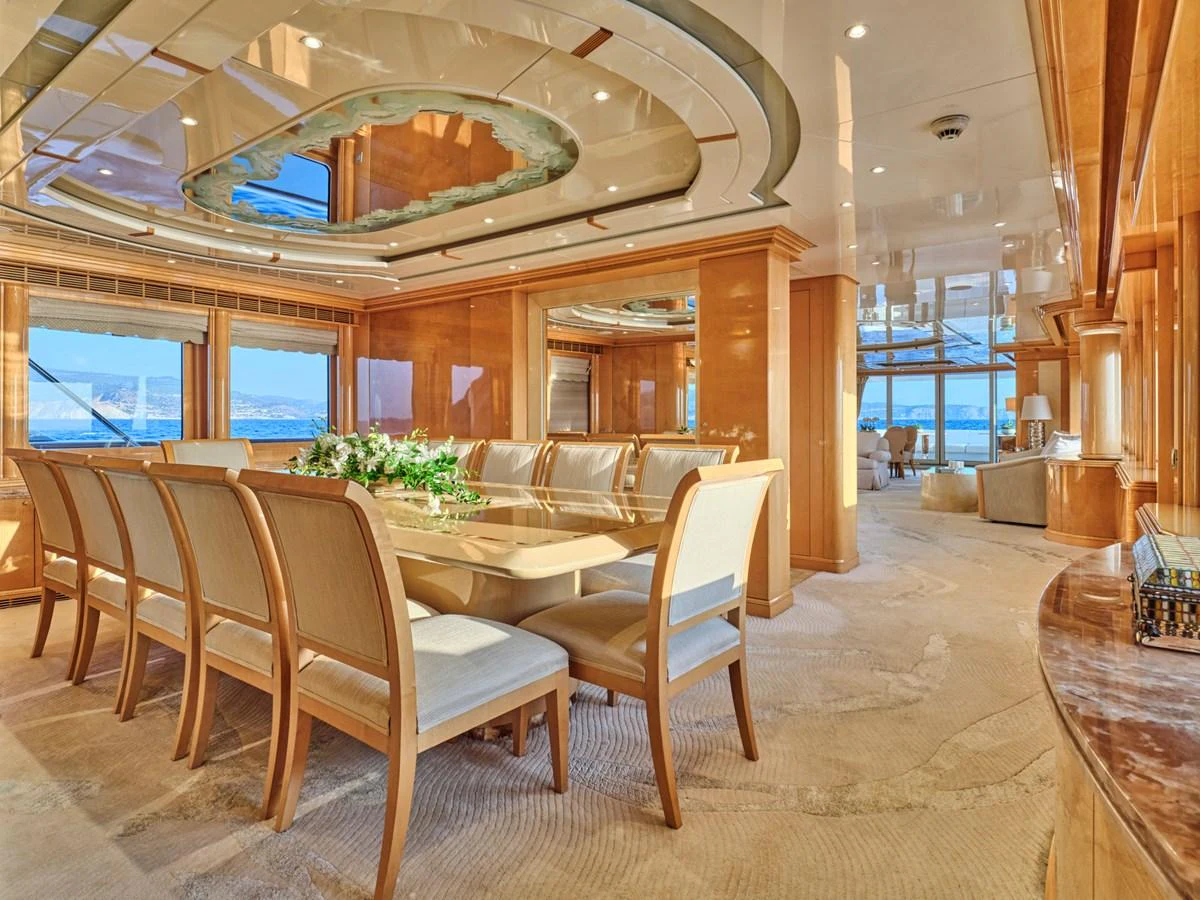 The yacht's dining area features elegant wooden furnishings and expansive windows offering stunning sea views. aboard BILMAR Yacht for Sale