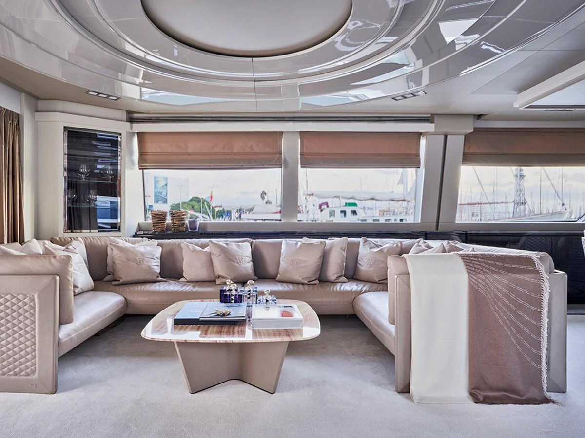 The salon features a spacious and elegant seating area with large windows offering a panoramic view. aboard UHUD Yacht for Sale