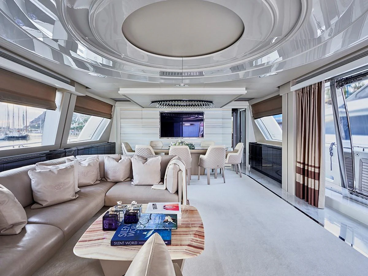 The salon features luxurious seating, a modern entertainment system, and elegant decor. aboard UHUD Yacht for Sale