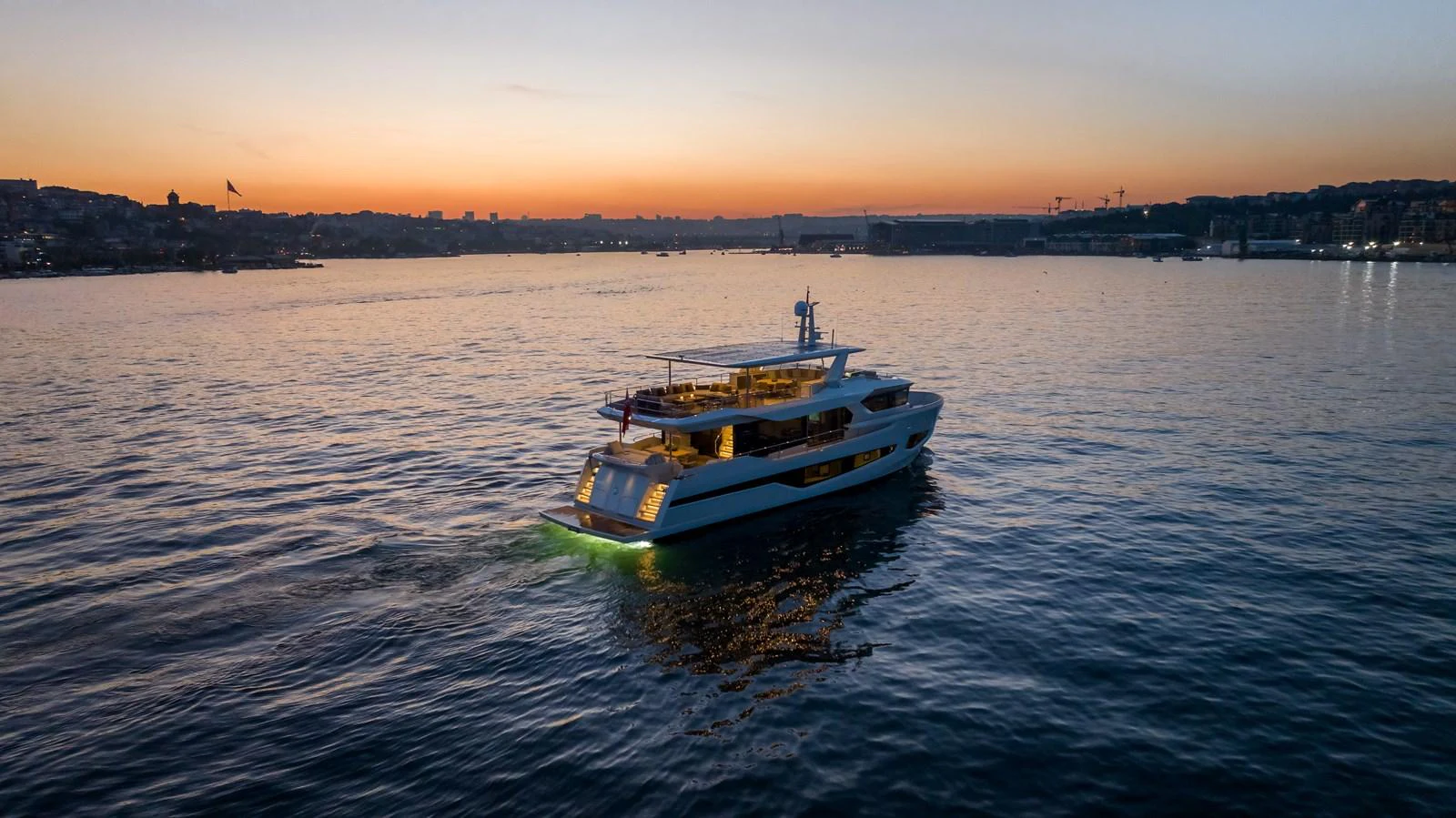 A luxurious yacht cruises through calm waters at sunset, showcasing its elegant design and serene ambiance. aboard NUMARINE 27XP#6 Yacht for Sale