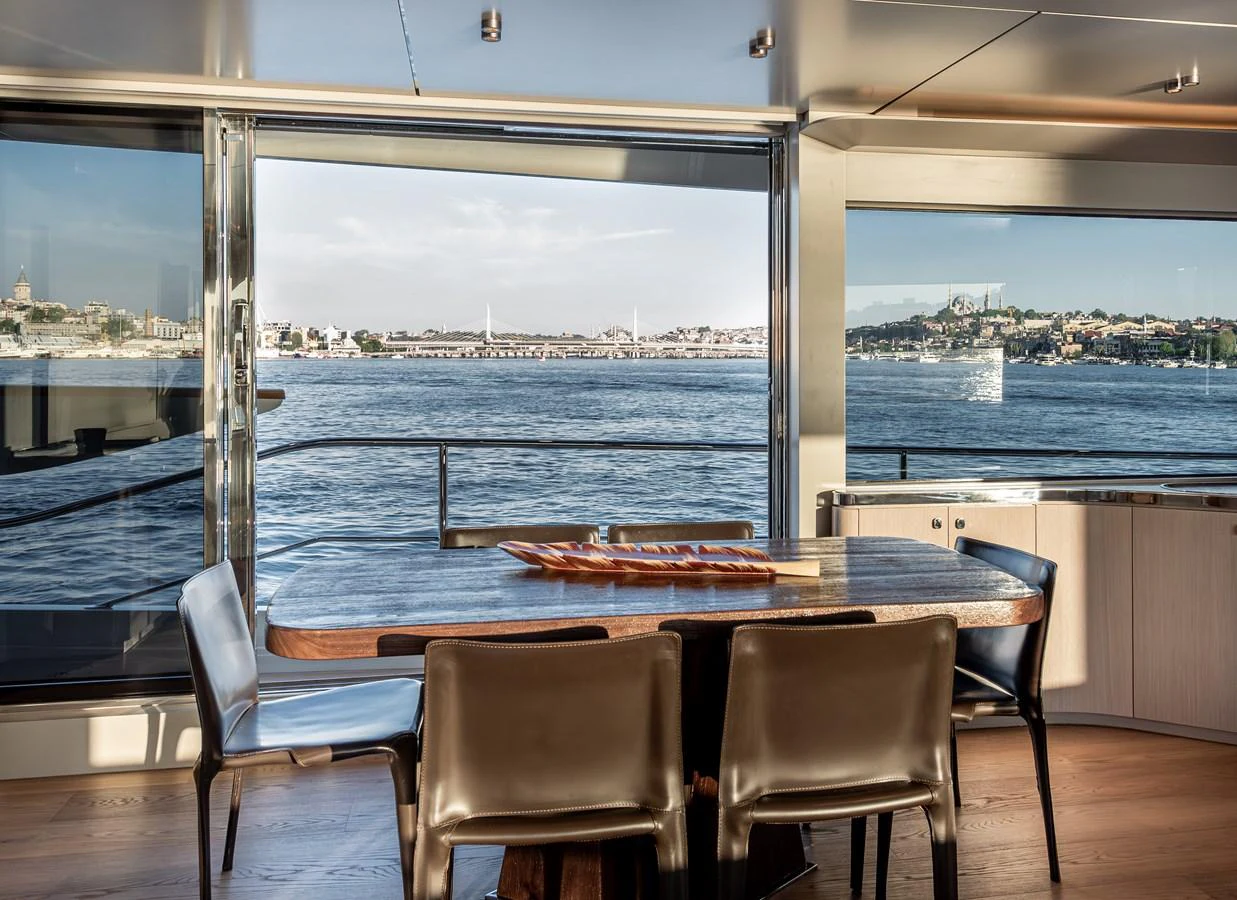 The yacht's dining area offers stunning views through large windows, creating a serene and elegant atmosphere. aboard NUMARINE 27XP#6 Yacht for Sale