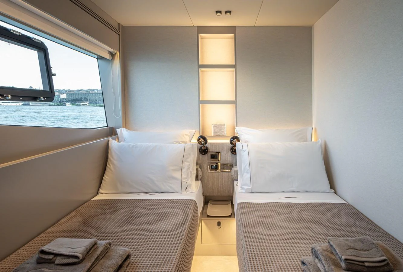 The guest stateroom features twin beds with a serene view through the window. aboard NUMARINE 27XP#6 Yacht for Sale