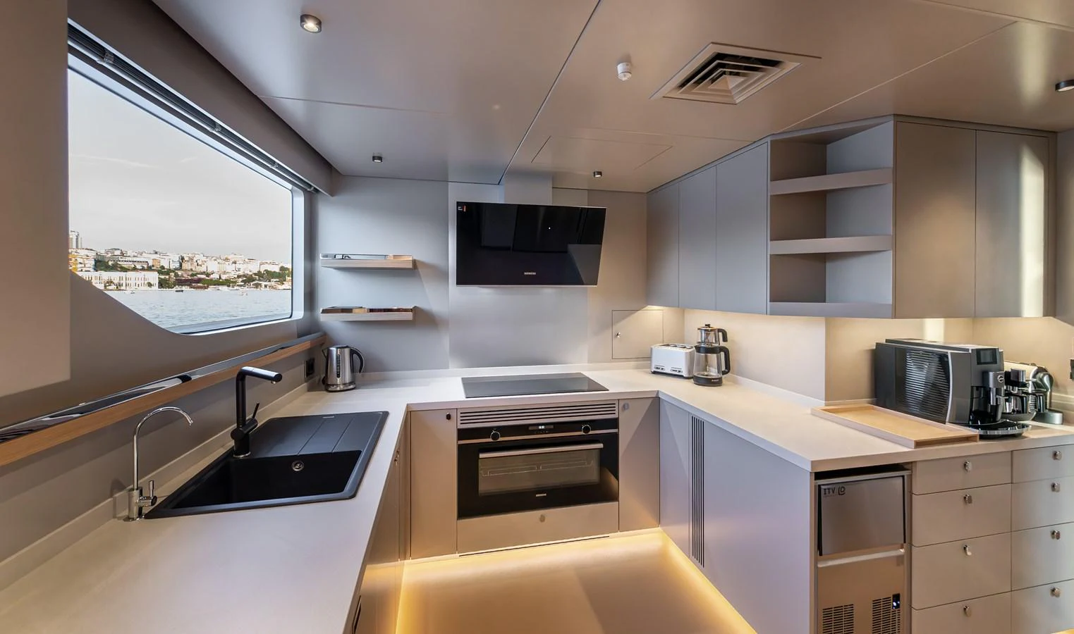 The modern galley features sleek appliances and ample counter space with a view of the water. aboard NUMARINE 27XP#6 Yacht for Sale