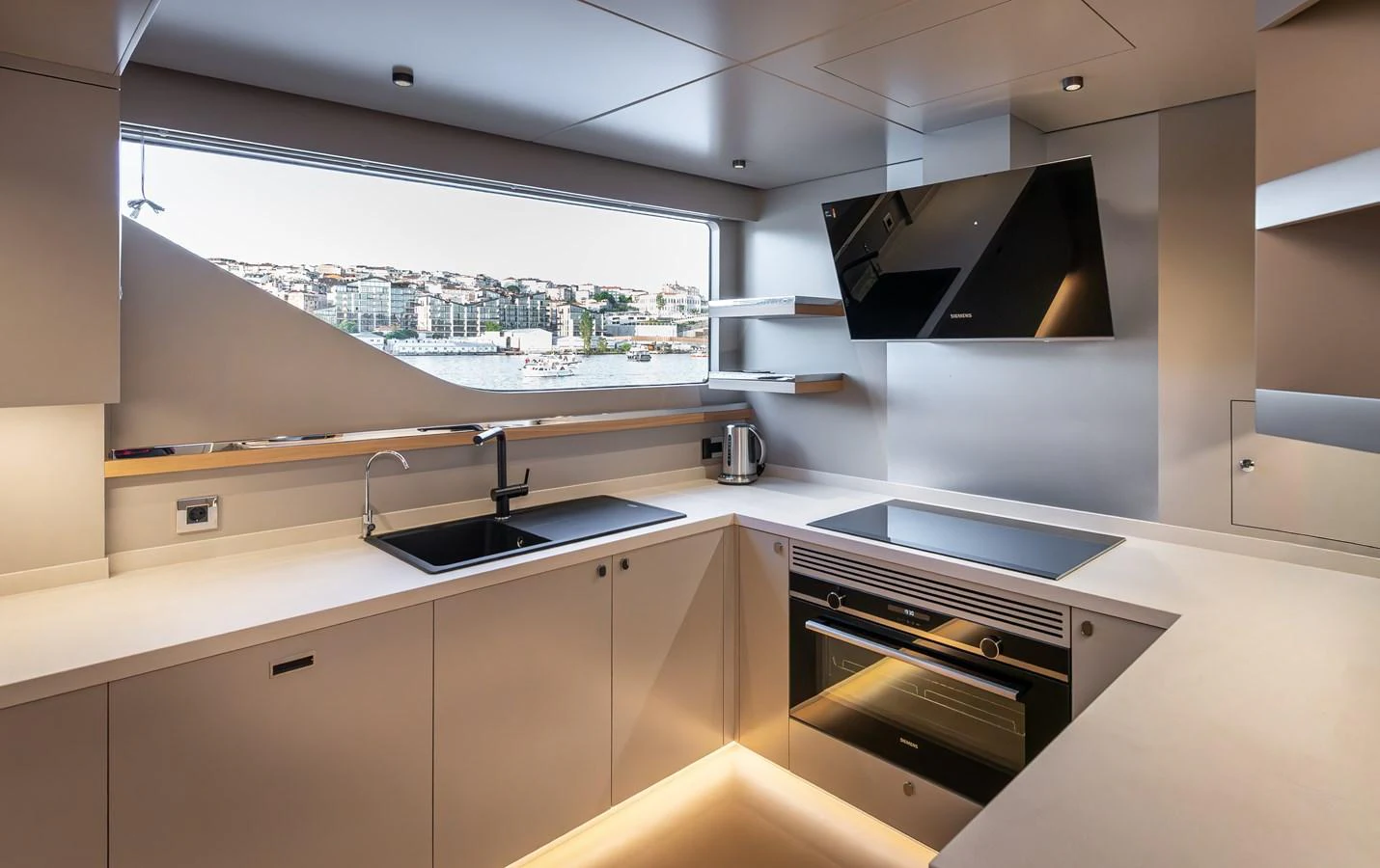 The yacht's galley features modern appliances and sleek design with a large window offering a scenic view. aboard NUMARINE 27XP#6 Yacht for Sale