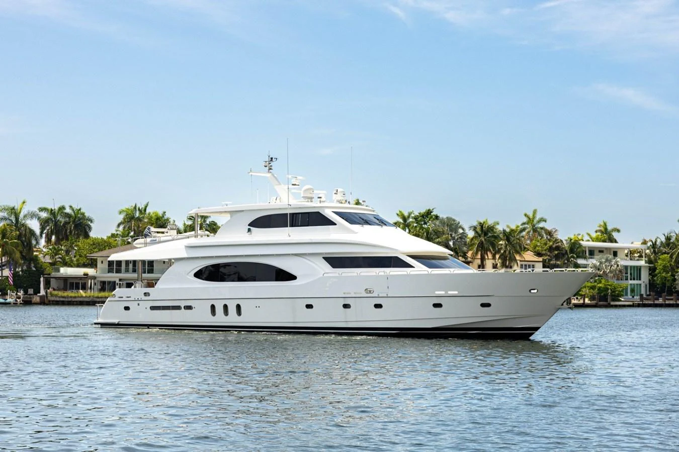 A sleek white yacht cruises gracefully on calm waters under a clear blue sky. aboard MY ANGEL Yacht for Sale