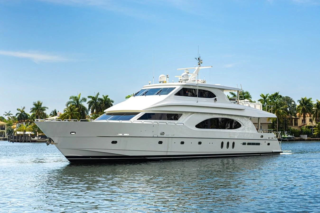 A luxurious yacht glides gracefully on calm waters with a backdrop of palm trees and clear skies. aboard MY ANGEL Yacht for Sale
