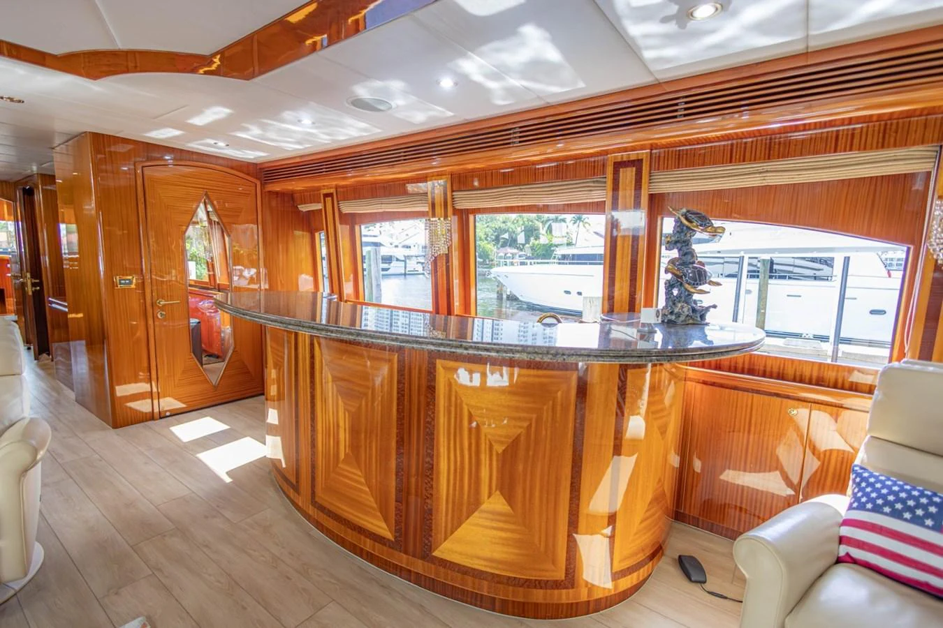 The yacht's salon features a luxurious bar area with polished wood finishes and large windows offering scenic views. aboard MY ANGEL Yacht for Sale