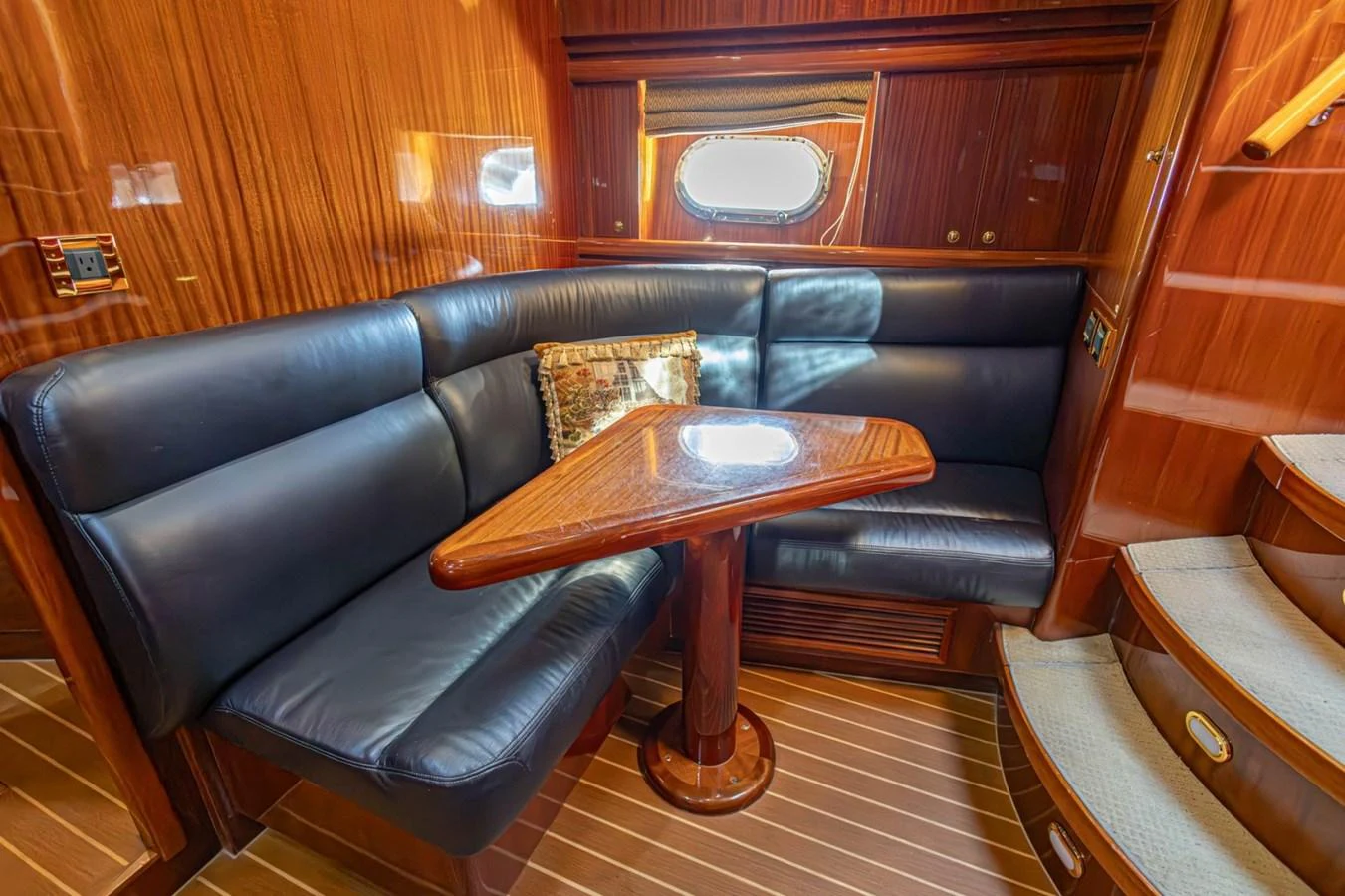 The yacht's saloon features a cozy seating area with a wooden table and plush leather cushions. aboard MY ANGEL Yacht for Sale