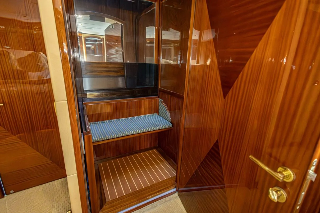 The image showcases a luxurious wooden interior with a small seating area and elegant finishes. aboard MY ANGEL Yacht for Sale