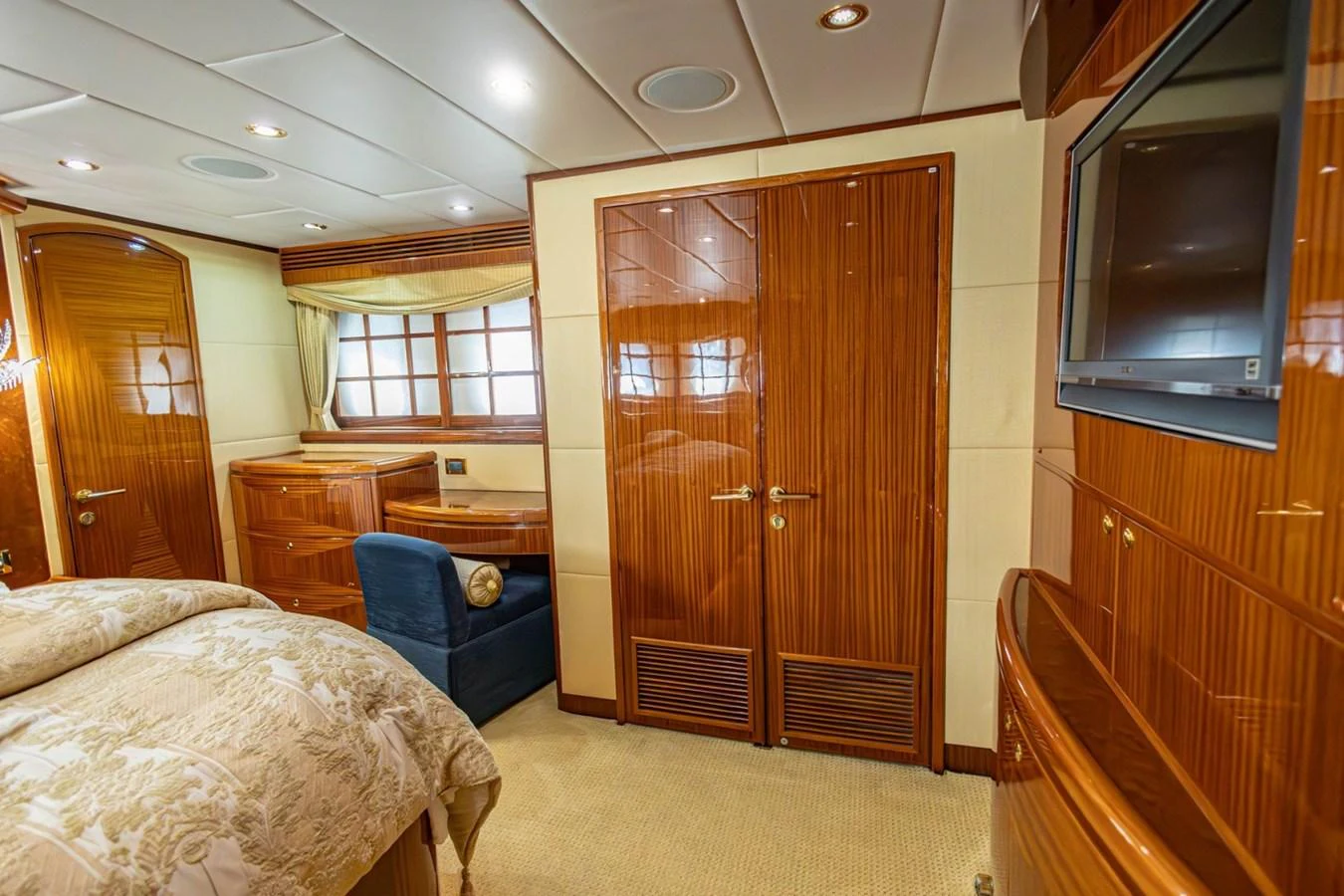 The stateroom features luxurious wood paneling, a comfortable bed, and a cozy seating area. aboard MY ANGEL Yacht for Sale