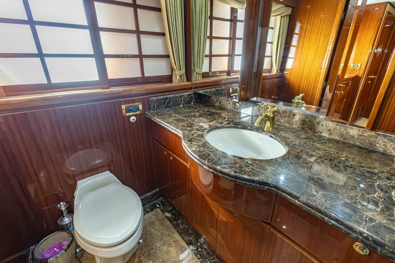 The yacht's bathroom features luxurious marble countertops and rich wood paneling. aboard MY ANGEL Yacht for Sale