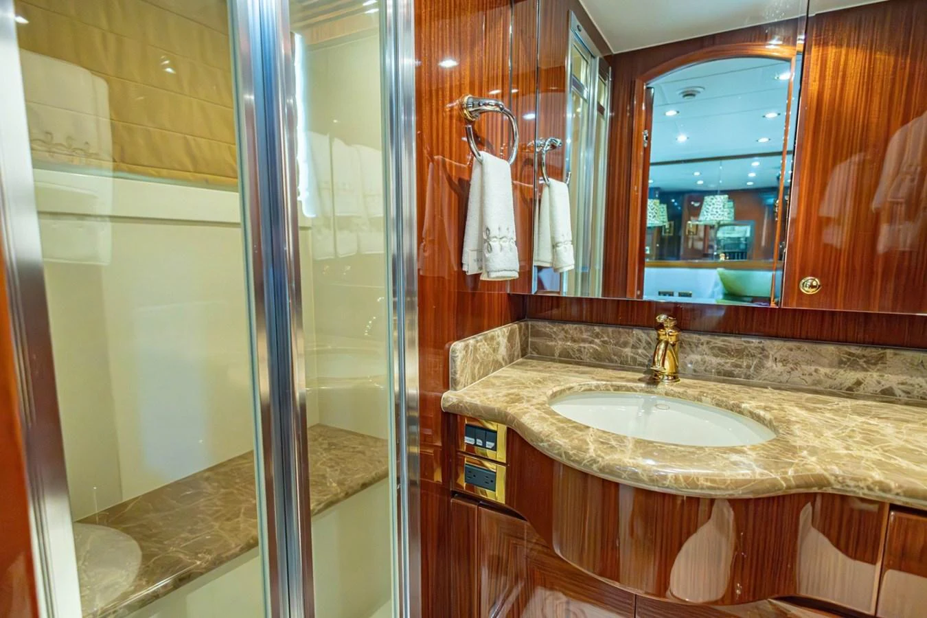 The yacht's bathroom features elegant wood paneling and a marble countertop, exuding luxury and sophistication. aboard MY ANGEL Yacht for Sale