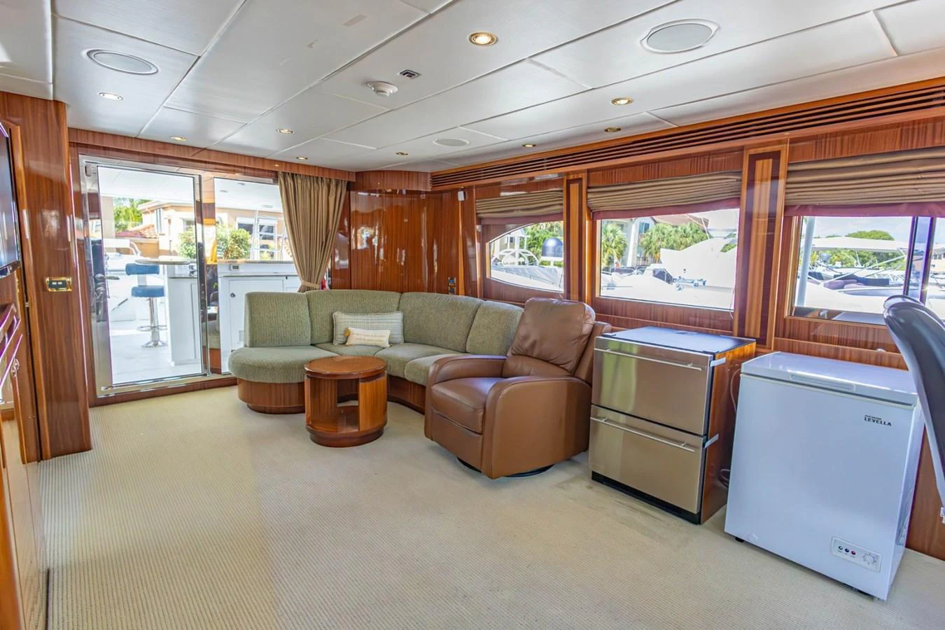 The salon features a cozy seating area with a mix of leather and fabric furnishings, complemented by large windows for natural light. aboard MY ANGEL Yacht for Sale