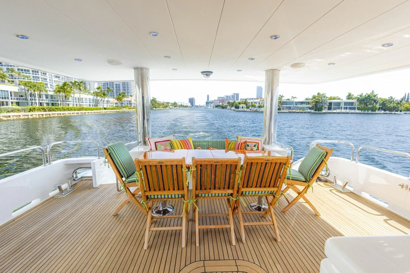 The aft deck features a spacious dining area with wooden chairs and a beautiful view of the water. aboard MY ANGEL Yacht for Sale