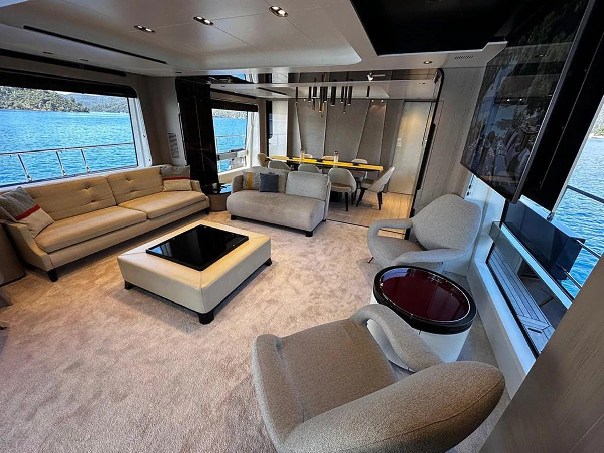 The spacious salon features luxurious seating and large windows offering stunning views. aboard ALEX10 Yacht for Sale