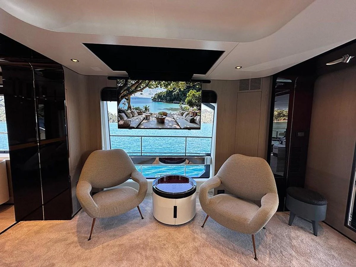 A luxurious yacht interior featuring modern seating and a large window with a scenic view. aboard ALEX10 Yacht for Sale
