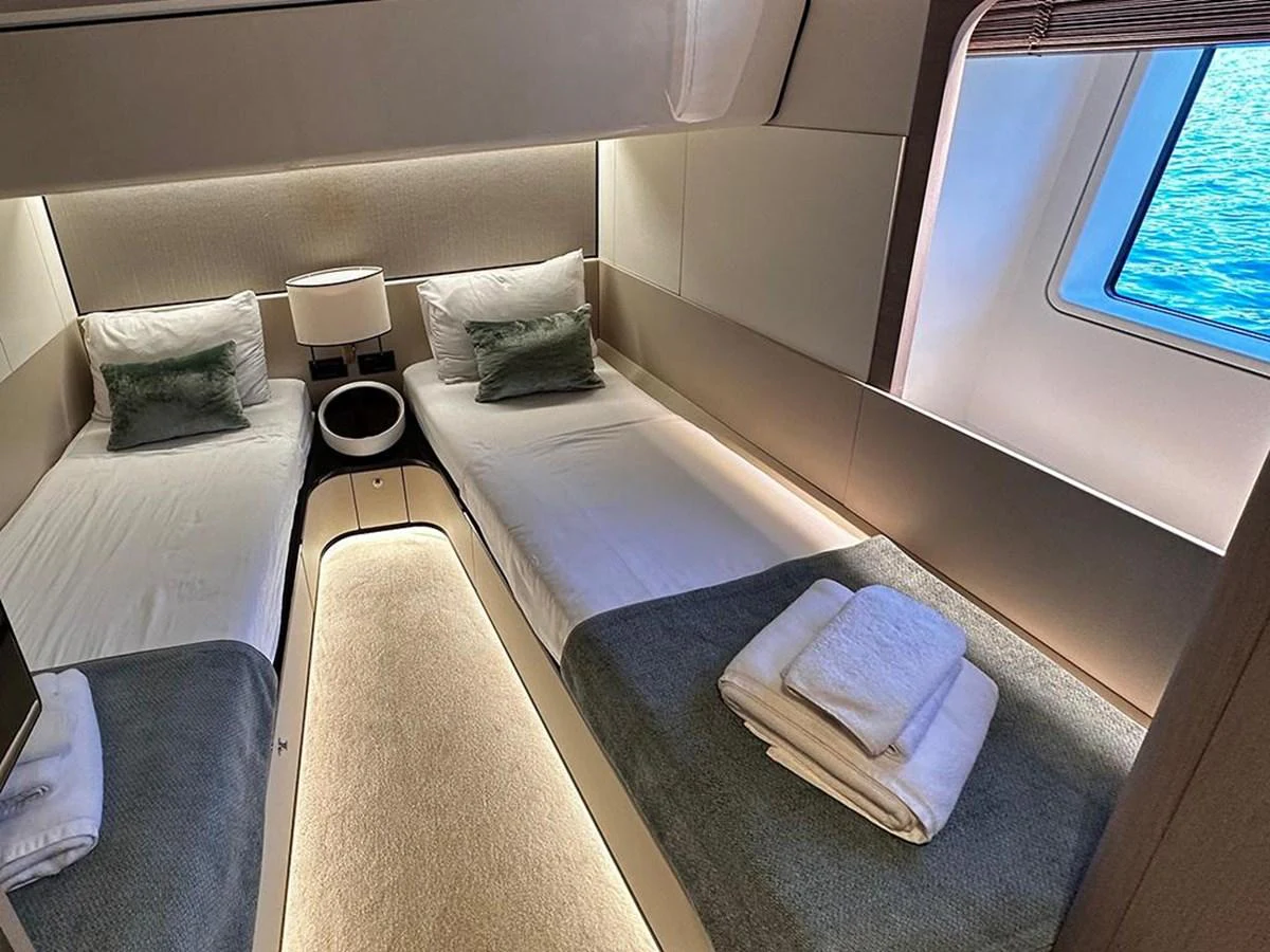 The twin cabin offers a cozy and well-lit space with two single beds and a view of the sea. aboard ALEX10 Yacht for Sale