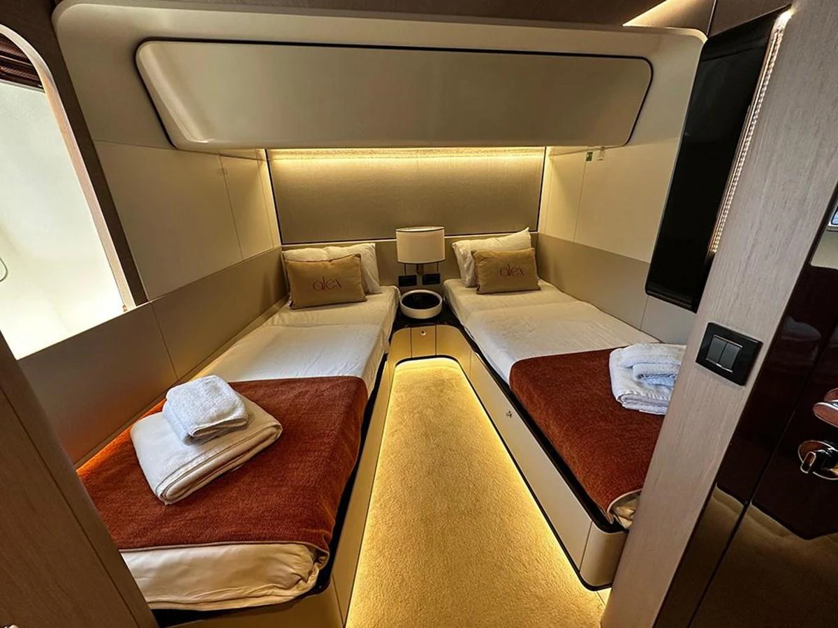The twin stateroom features two single beds with luxurious linens and ambient lighting. aboard ALEX10 Yacht for Sale