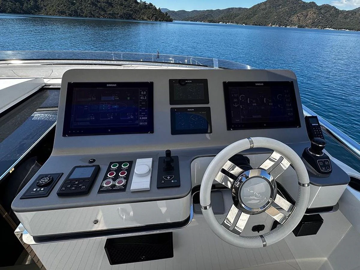 The helm station features advanced navigation equipment and a sleek steering wheel, offering a commanding view of the serene waters ahead. aboard ALEX10 Yacht for Sale