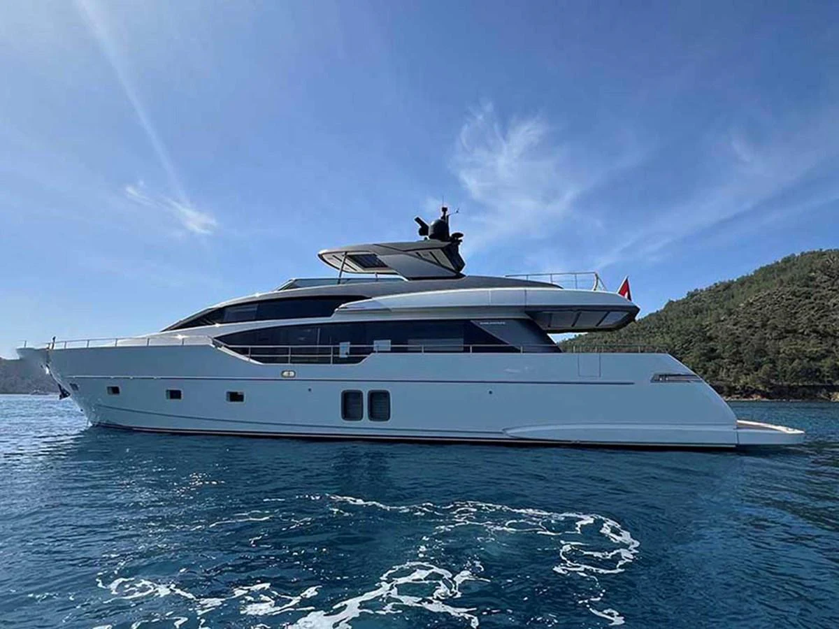 A sleek and modern yacht glides gracefully on calm waters under a clear blue sky. aboard LA ISLA Yacht for Sale