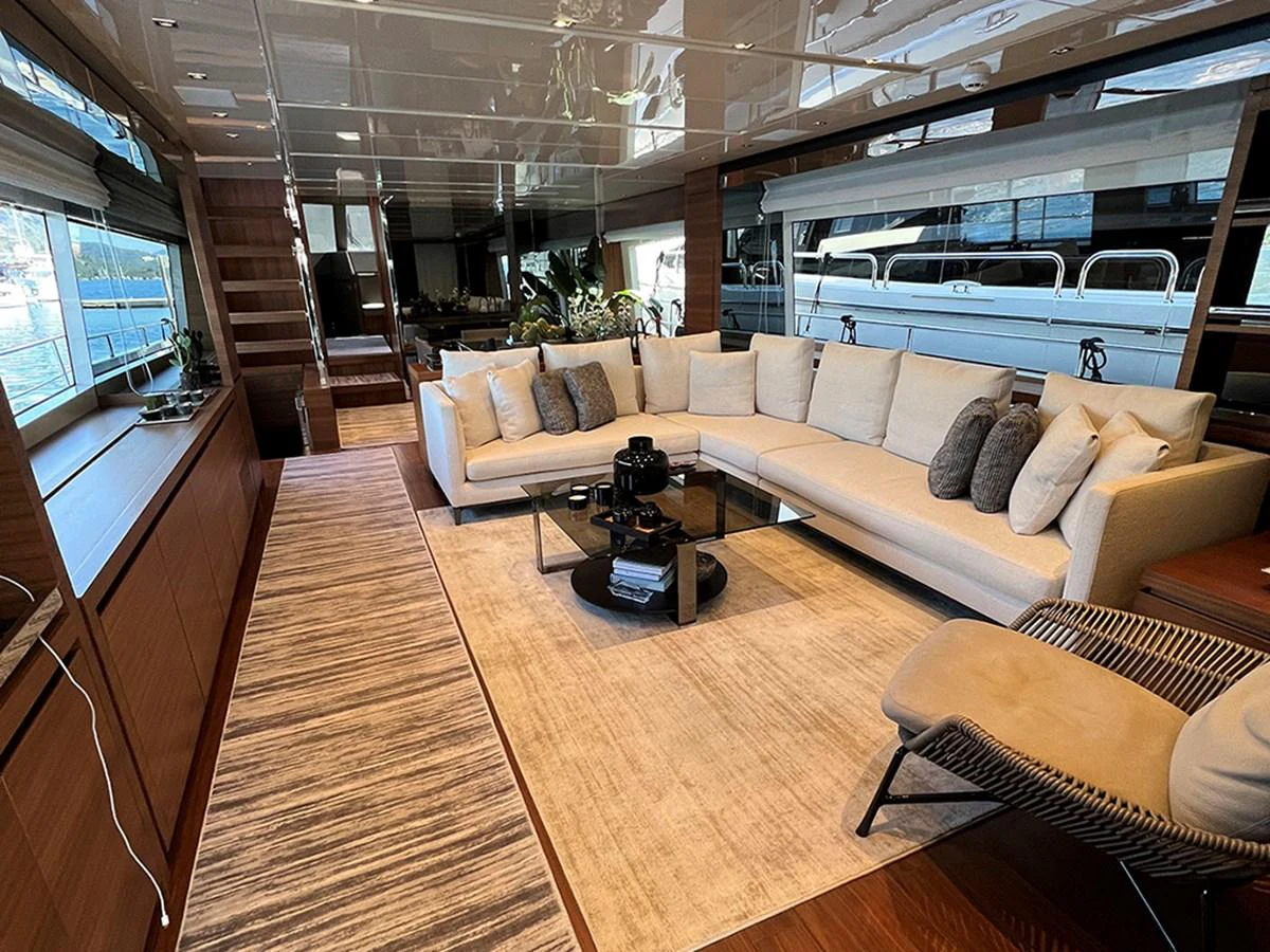 The yacht's salon features a spacious and elegant seating area with large windows offering stunning views. aboard LA ISLA Yacht for Sale