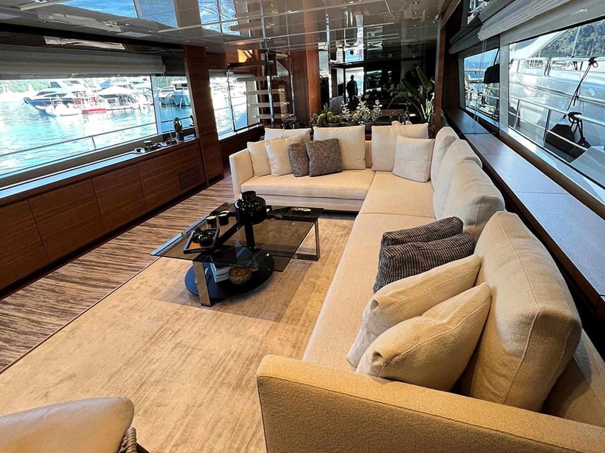 The salon features a spacious and elegant seating area with a large, comfortable sofa and modern decor. aboard LA ISLA Yacht for Sale