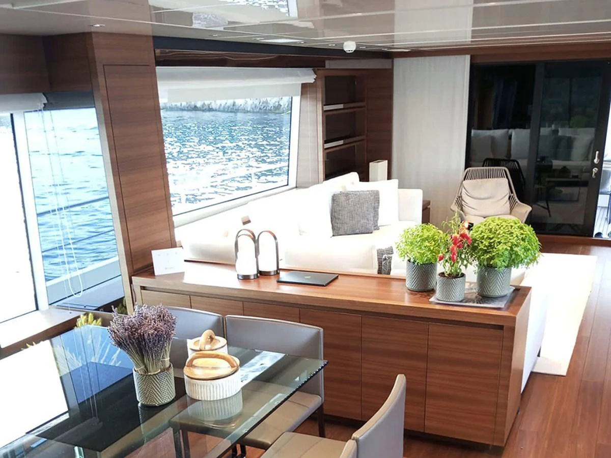 The yacht's salon features a modern and inviting space with large windows offering stunning water views. aboard LA ISLA Yacht for Sale